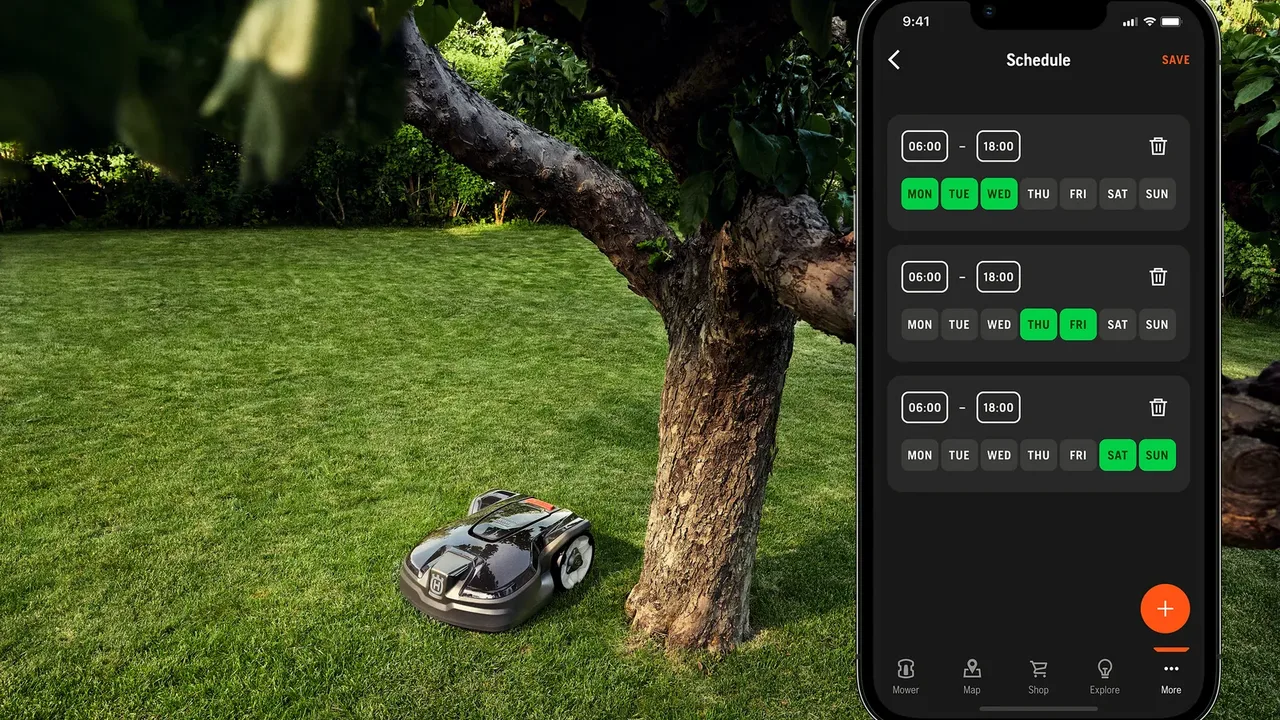 Робот-газонокосарка Husqvarna і смартфон із додатком Automower Connect у саду